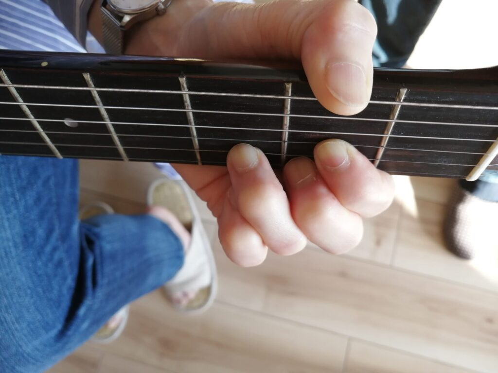 手元を写した、ギターのDコードを押さえている画像